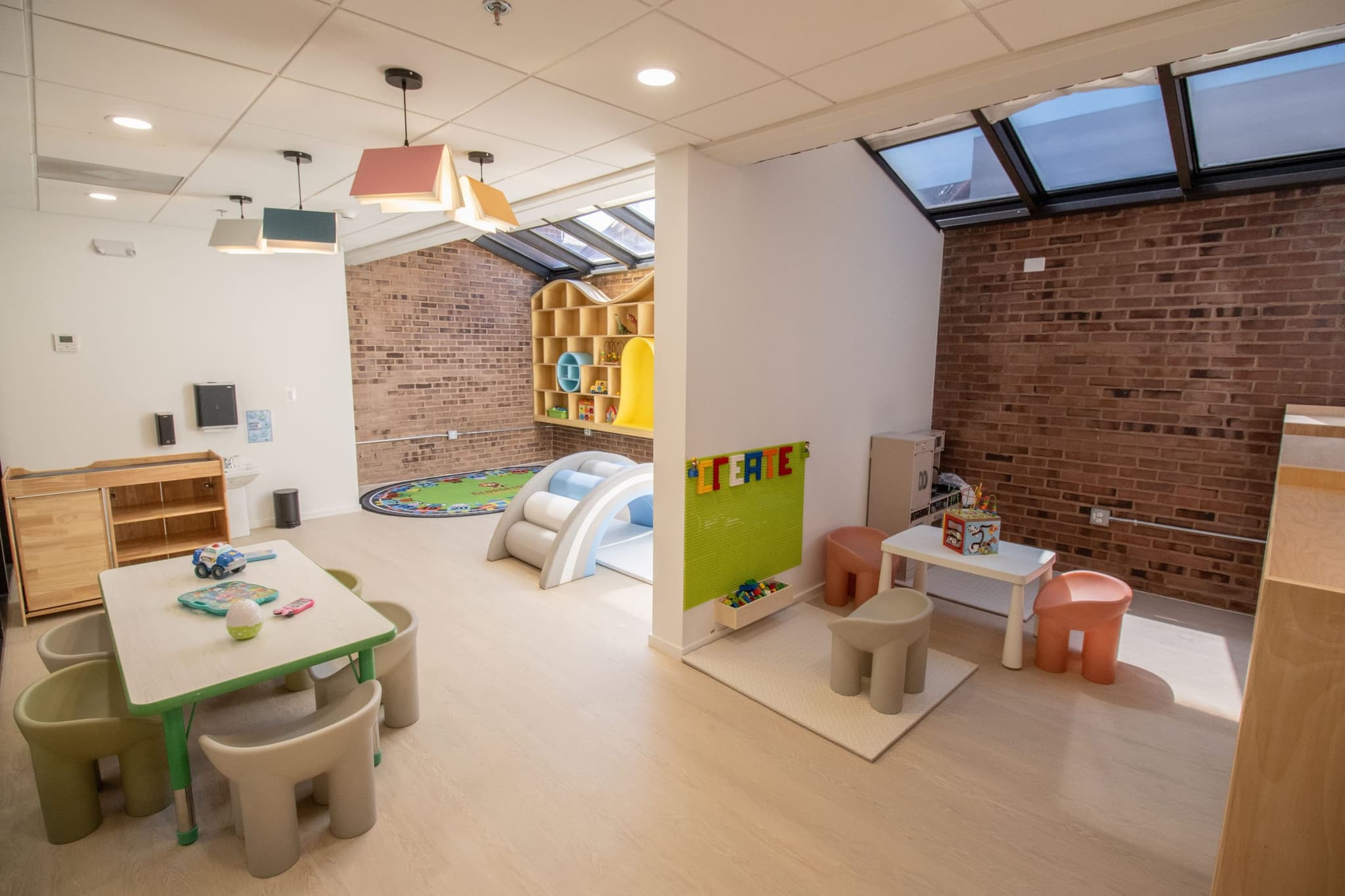 classroom interior with toys, brick accent wall and skylight