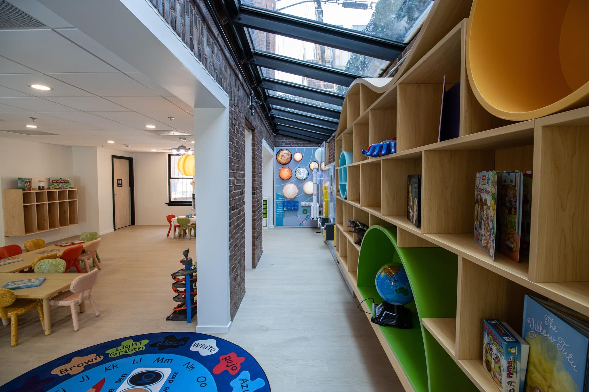 bright library/reading-nook hallway with built-in bookshelves and a skylight
